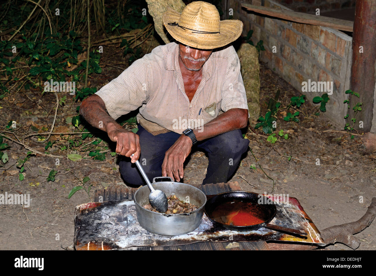 Le Brésil. Pantanal : Mister Sebastiao cuisiner son dîner dans un camp en plein air Banque D'Images
