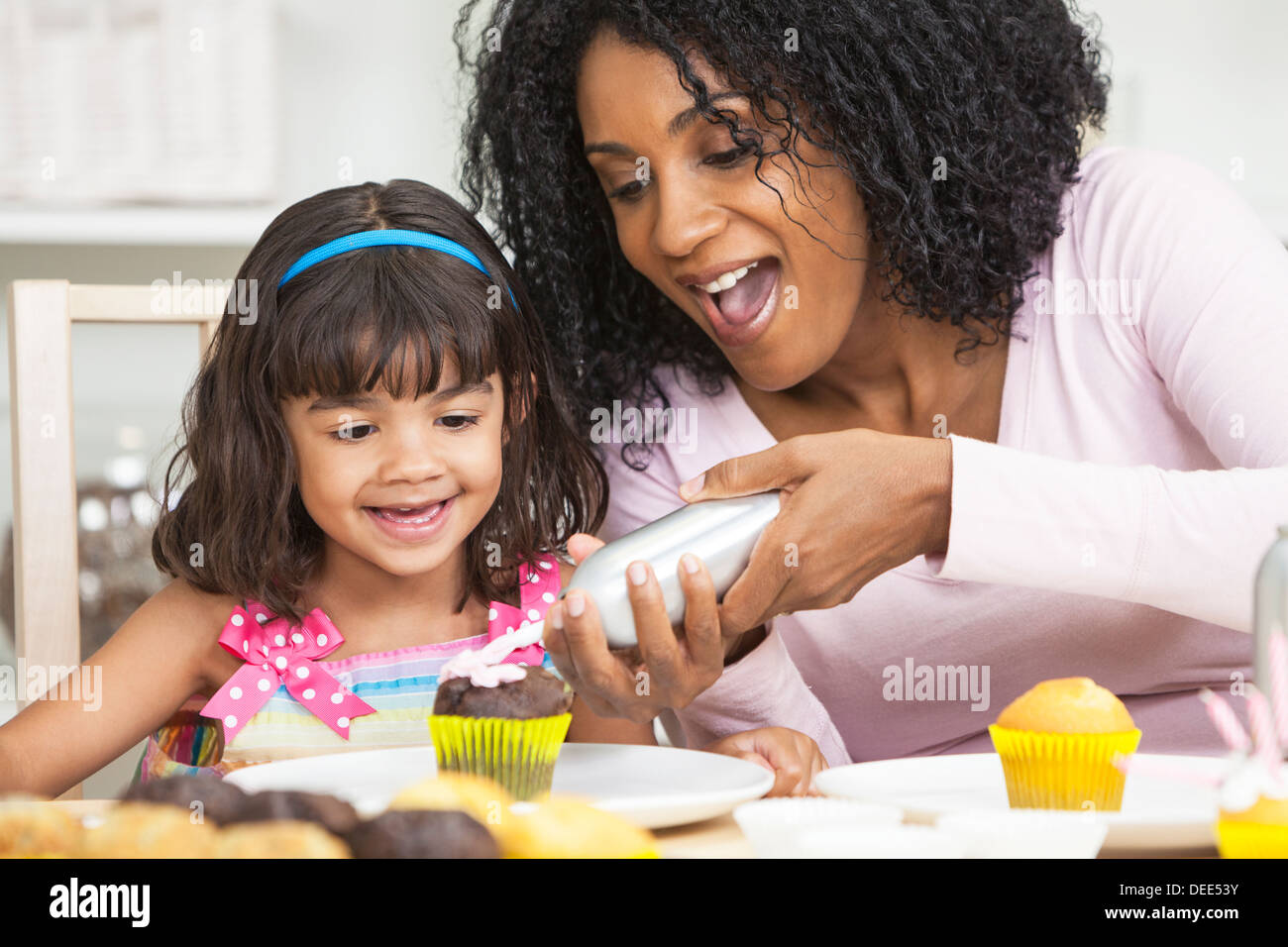 African American mother and young daughter having fun cup cakes glaçage glaçage Banque D'Images