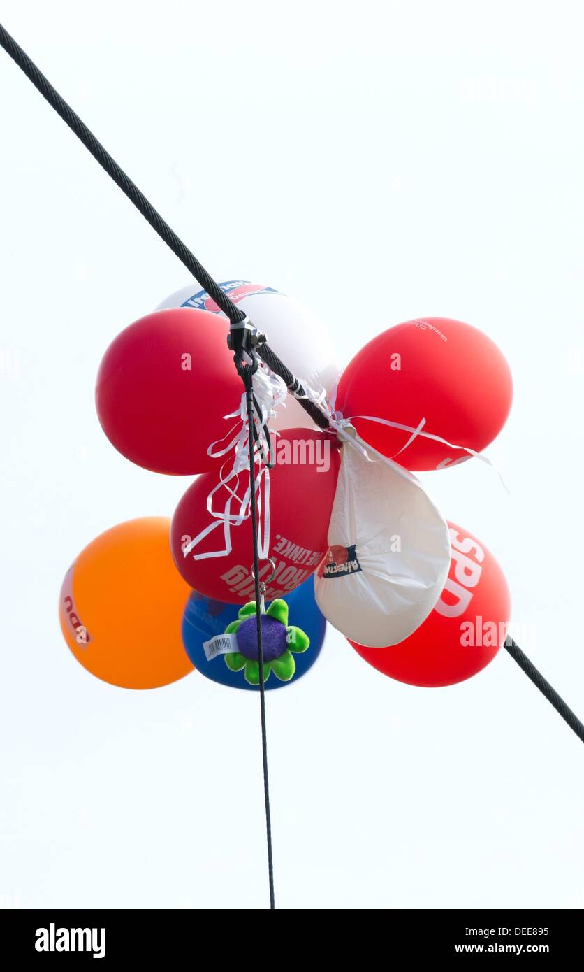 Un paquet de ballons publicitaires présentant les logos des différents partis politiques est pris dans une ligne électrique à Berlin, Allemagne, 17 septembre 2013. L'élection générale de la Bundestag va avoir lieu le dimanche 22 septembre 2013. Photo : Joerg Carstensen Banque D'Images