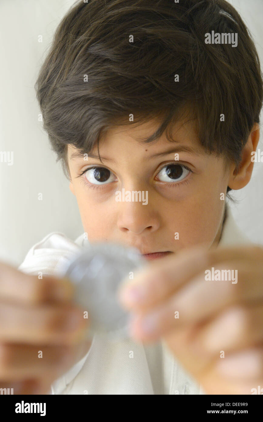 Boy holding silver coin Banque D'Images
