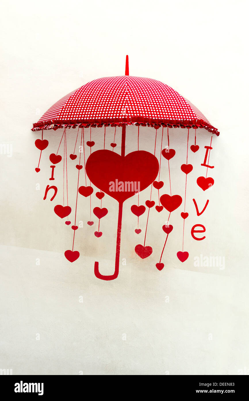 Parapluie rouge sur blanc mur de béton. Banque D'Images