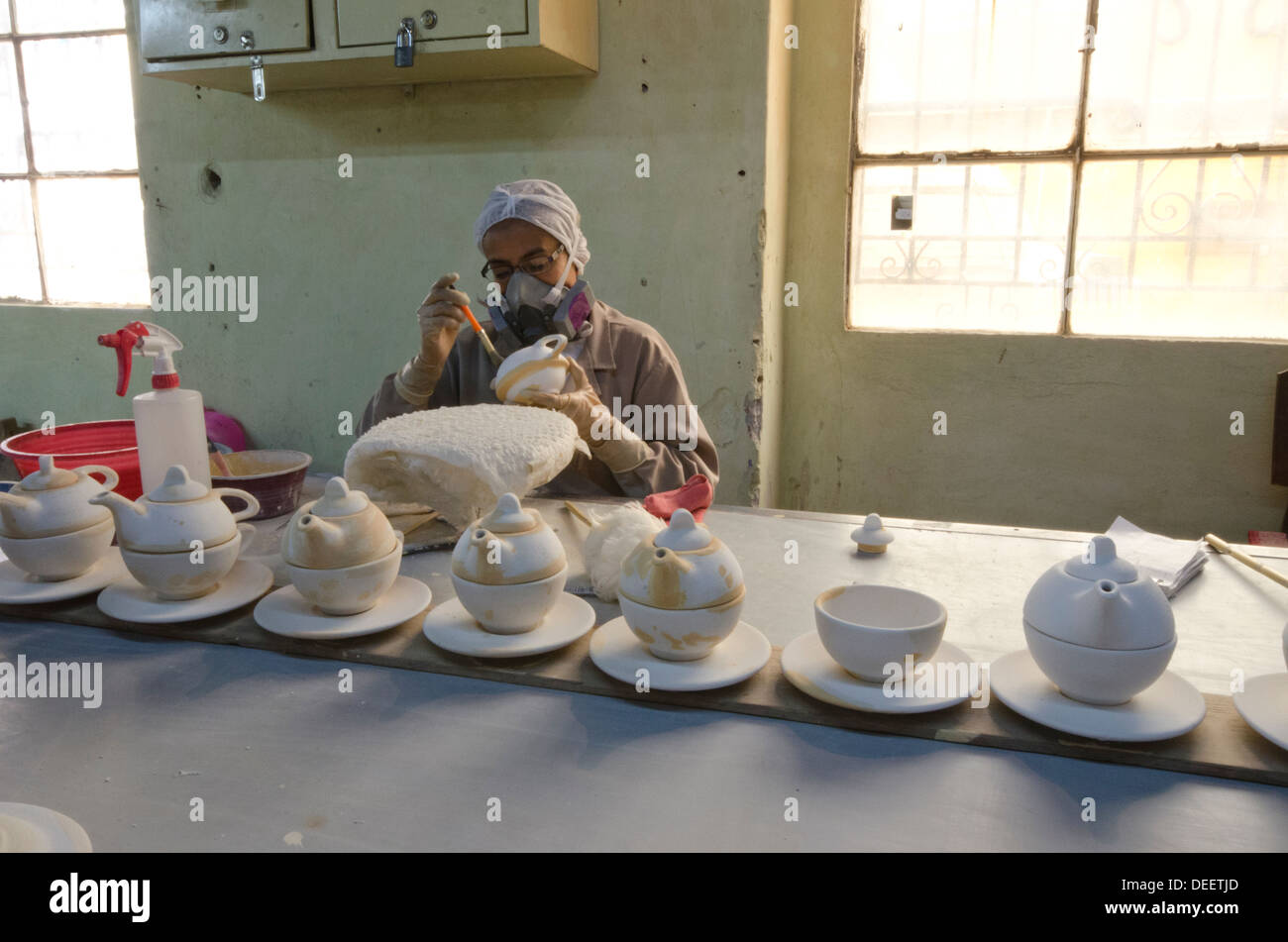 Retouche sur zones femme émaillé décoration théières avant et dernier feu sur l'Uriarte talavera usine à Puebla, Mexique Banque D'Images