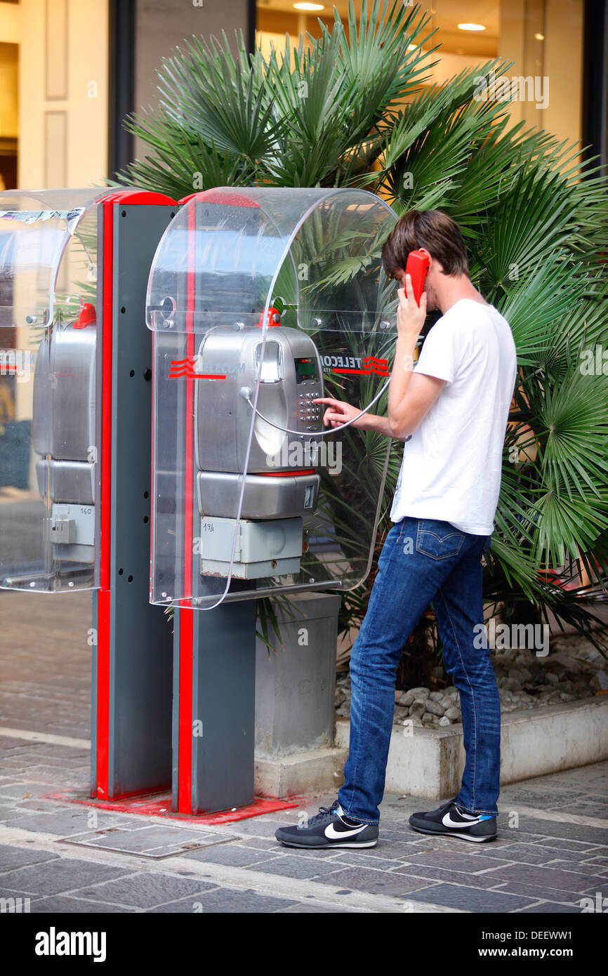 Un homme à l'aide d'un téléphone payant de Telecom Italia à Pescara, Italie. Banque D'Images