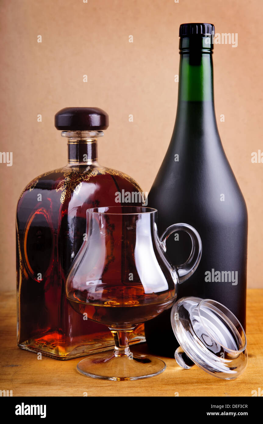 Bouteilles en verre et de brandy ou de cognac sur un fond de bois vintage Banque D'Images