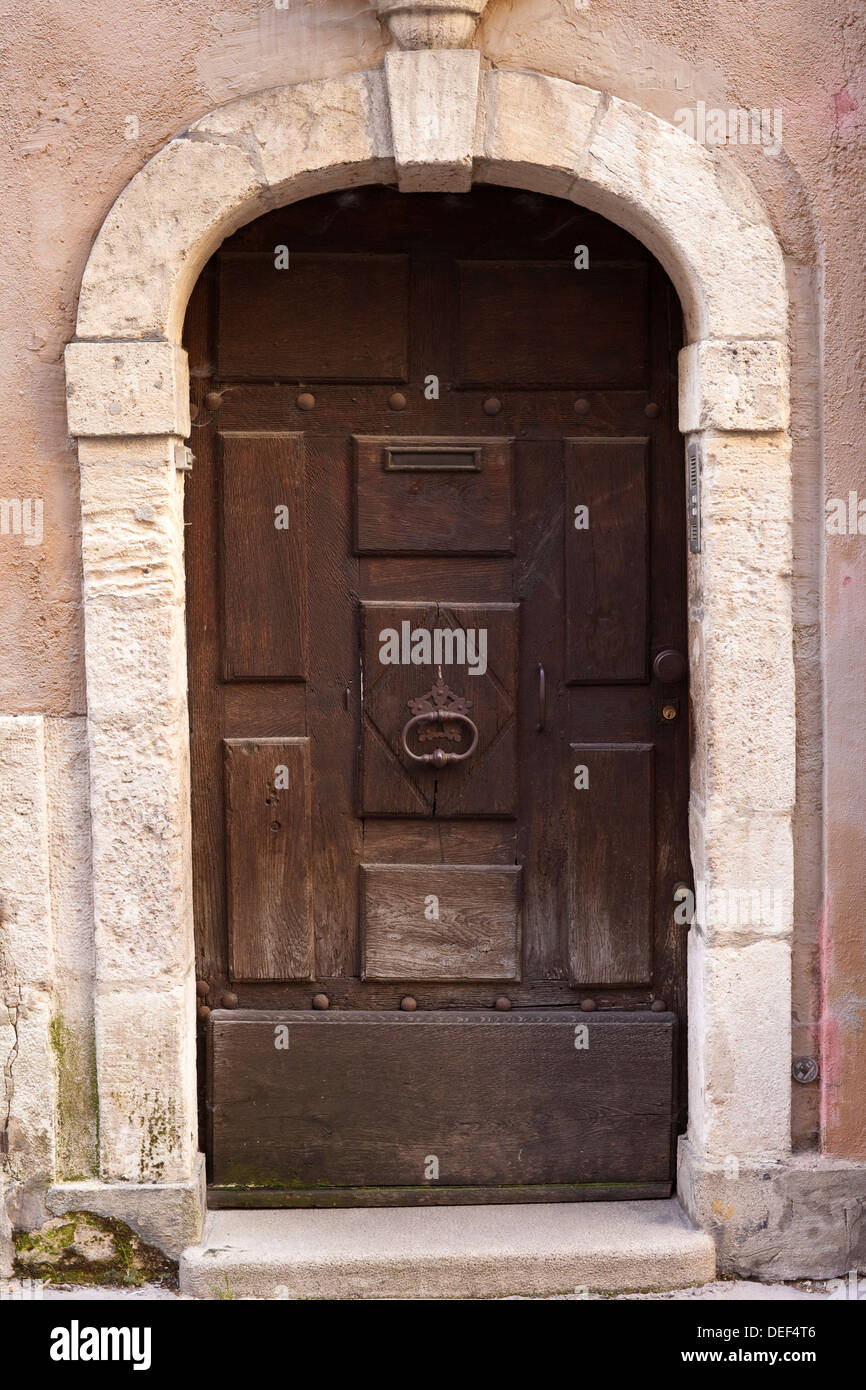 Une vieille porte en bois sous une arche de pierre Banque D'Images