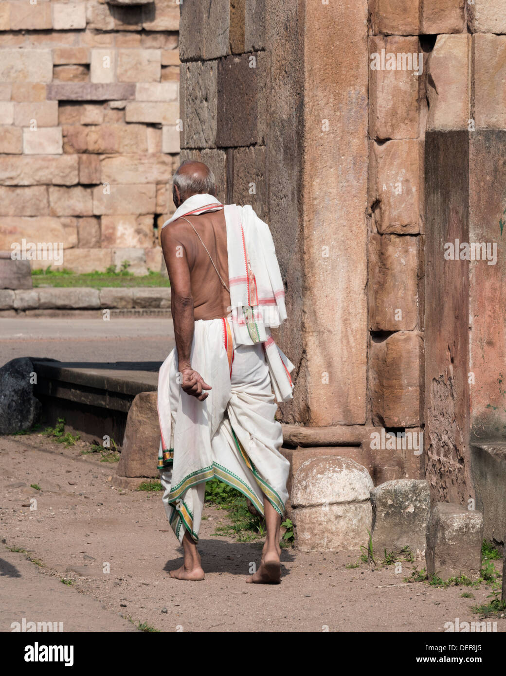 Pieds nus homme portant dhoti en passant par l'Est, porte de Bhadra Champaner, Inde Banque D'Images