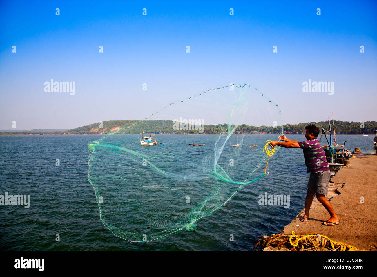 Pêcheur de jeter un filet de pêche dans la mer, le port de Zborište, Zborište, Bardez, North Goa, Goa, Inde Banque D'Images