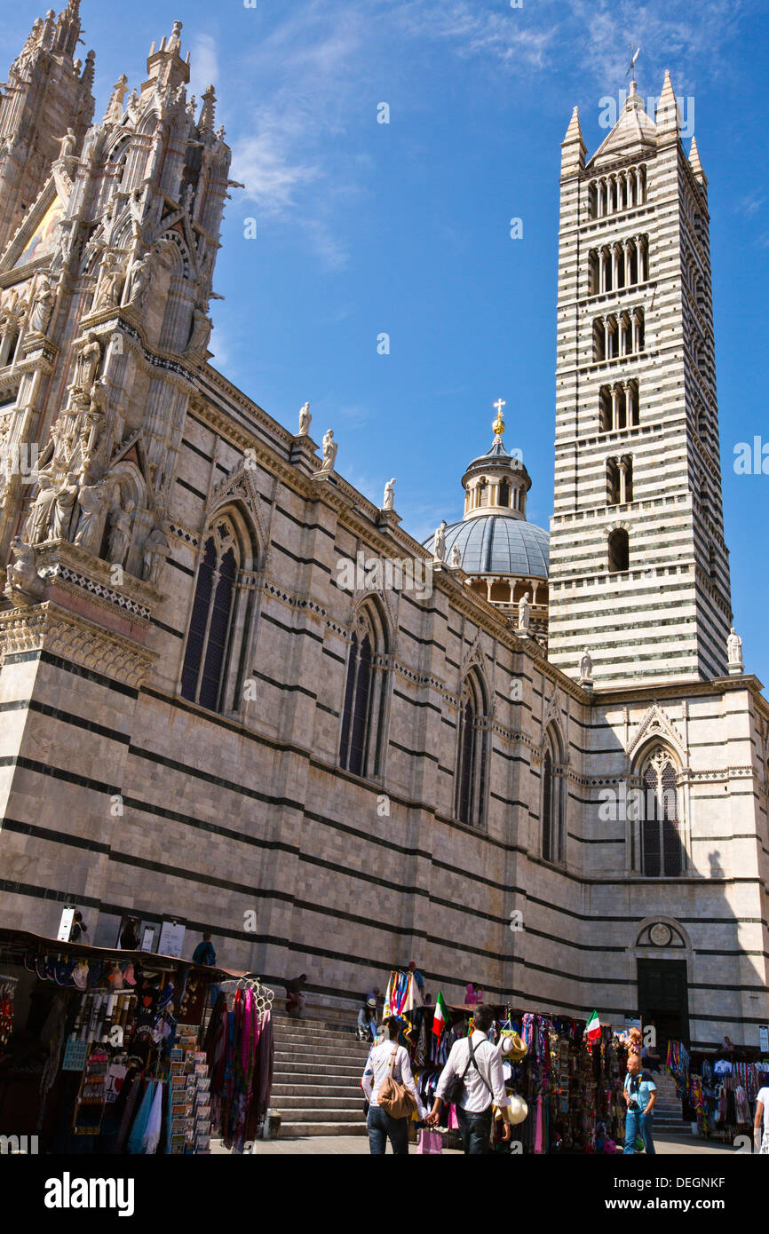 Les gens du shopping dans un marché de rue en face d'une cathédrale, le Duomo di Siena, Sienne, Toscane, Italie Banque D'Images