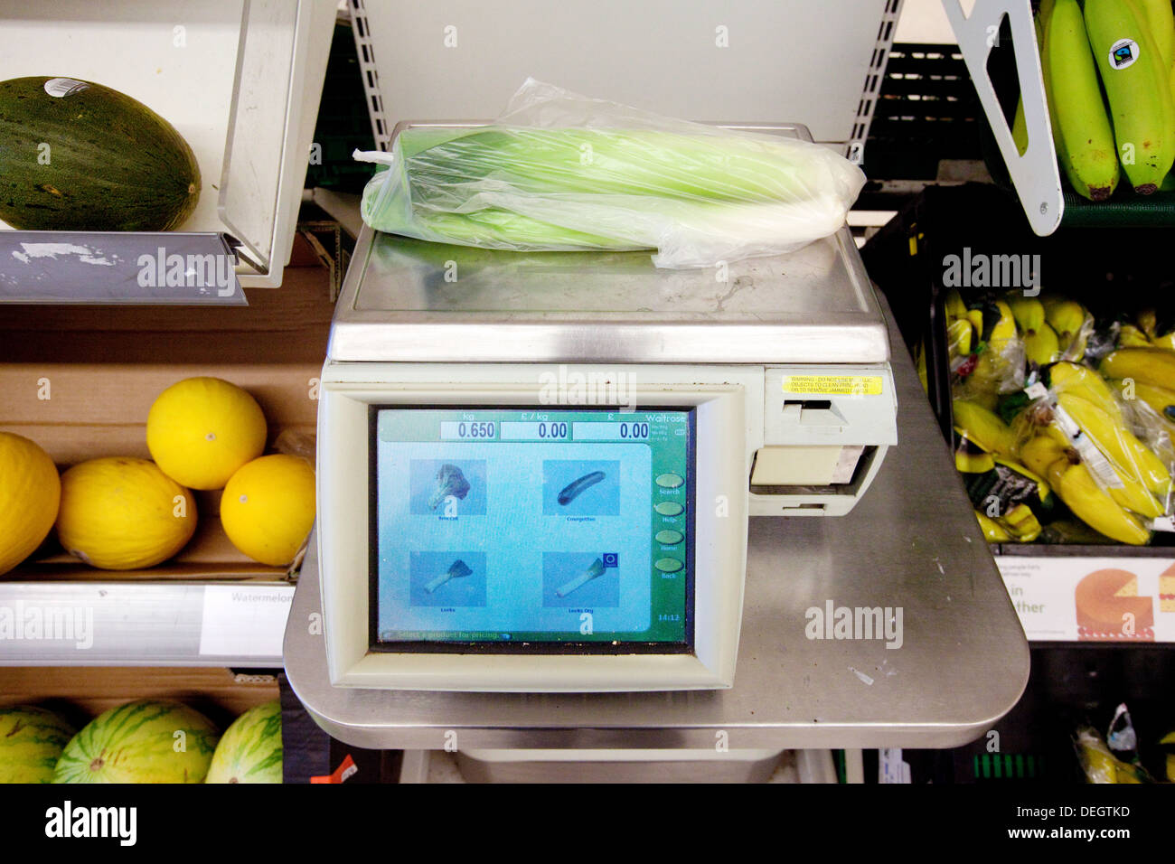 L'achat de fruits et légumes dans un supermarché Waitrose, avec des balances, Newmarket Suffolk UK Banque D'Images