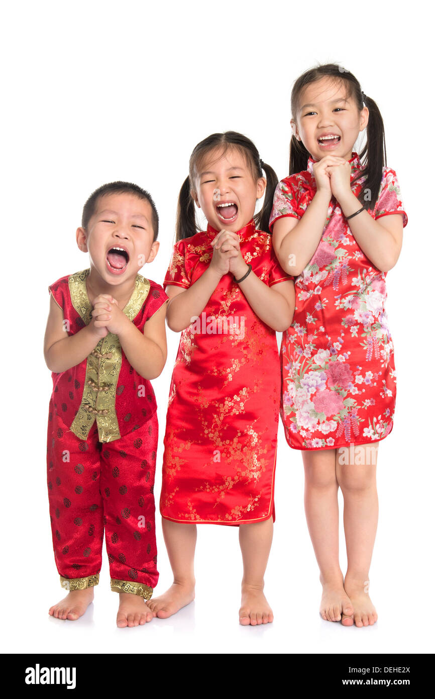 Groupe d'enfants d'Orient vous souhaiter une bonne nouvelle année chinoise, avec pleine longueur Cheongsam traditionnel article isolé sur fond blanc. Banque D'Images