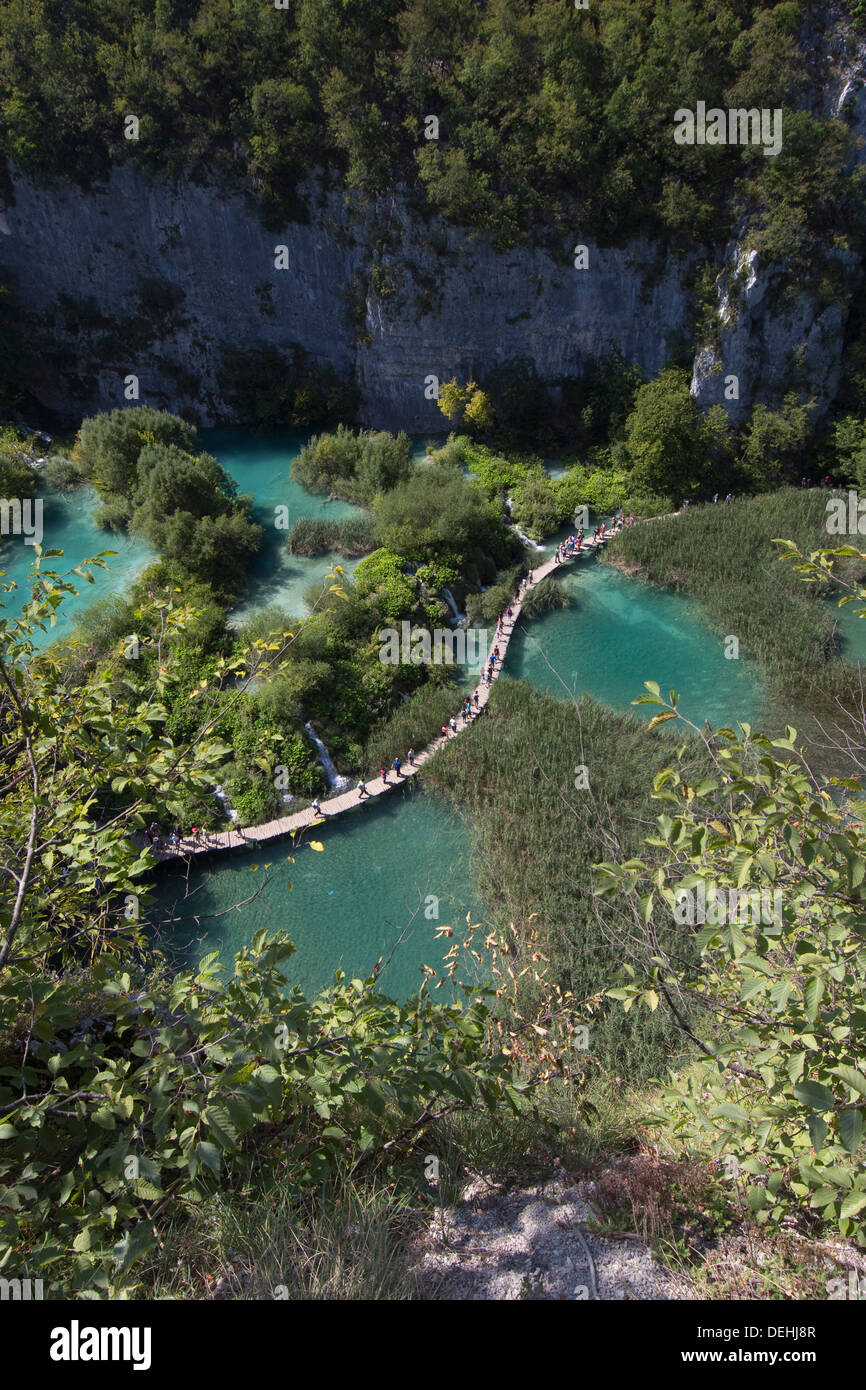 Les touristes marchant sur une passerelle à travers lacs turquoise au parc national des Lacs de Plitvice, Croatie Banque D'Images