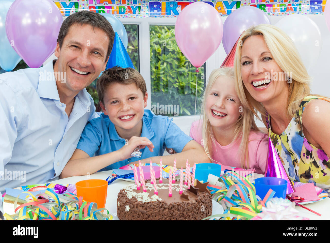 Famille heureuse, mère, père, fils et fille de célébrer une fête d'anniversaire de l'enfant avec le gâteau Banque D'Images