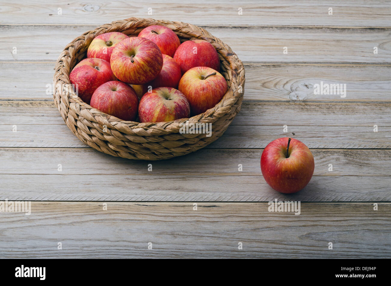 La vie encore. Panier de pommes rouges sur table en bois Banque D'Images