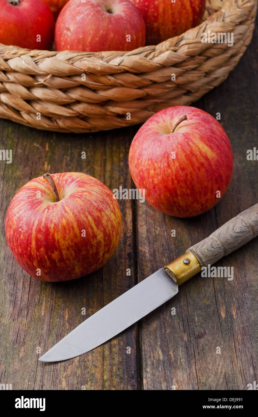 Panier de pommes et le couteau sur la table en bois Banque D'Images