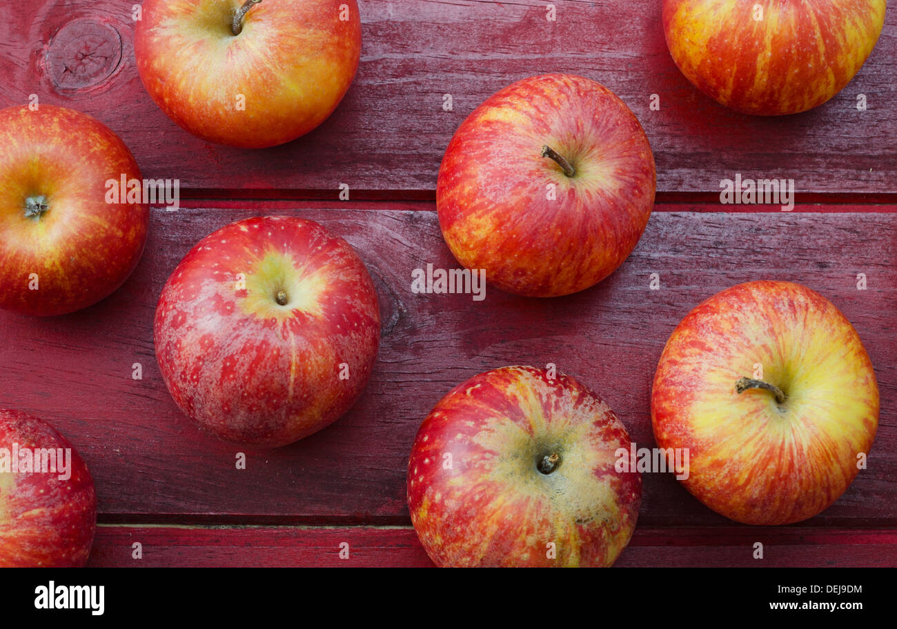 Plusieurs pommes rouges sur le bois rouge de table Banque D'Images