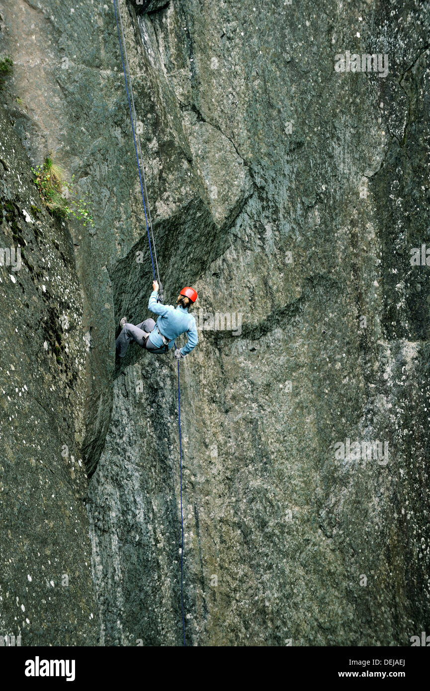 Woman down l'ardoise rock face de cathédrale Quarry en peu de Langdale, Parc National de Lake District, Cumbria, Angleterre Banque D'Images