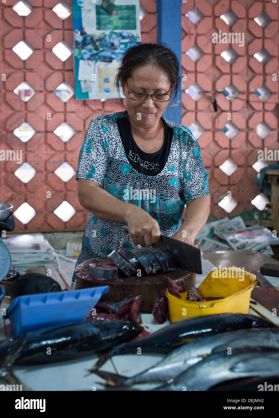 Femme Asiatique de couper du poisson frais dans le marché, Labuan Banque D'Images