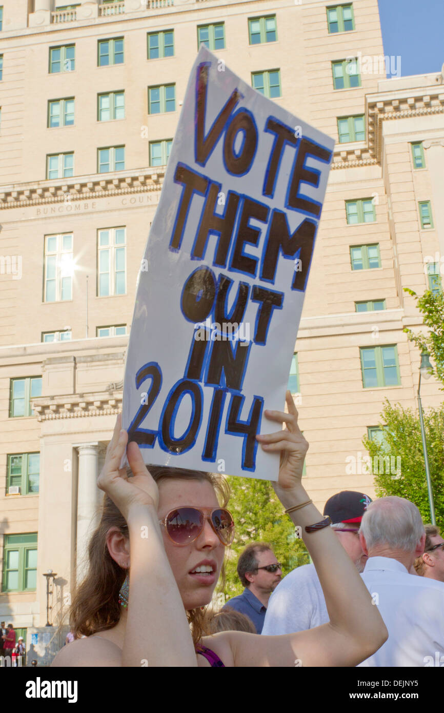 Jeune femme affiche un "vote en 2014" signe en un rassemblement politique morale lundi dans le centre-ville de Asheville Banque D'Images