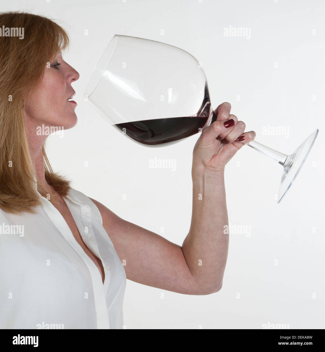 Dégustation de femme à partir d'un très grand verre de vin rouge Photo  Stock - Alamy