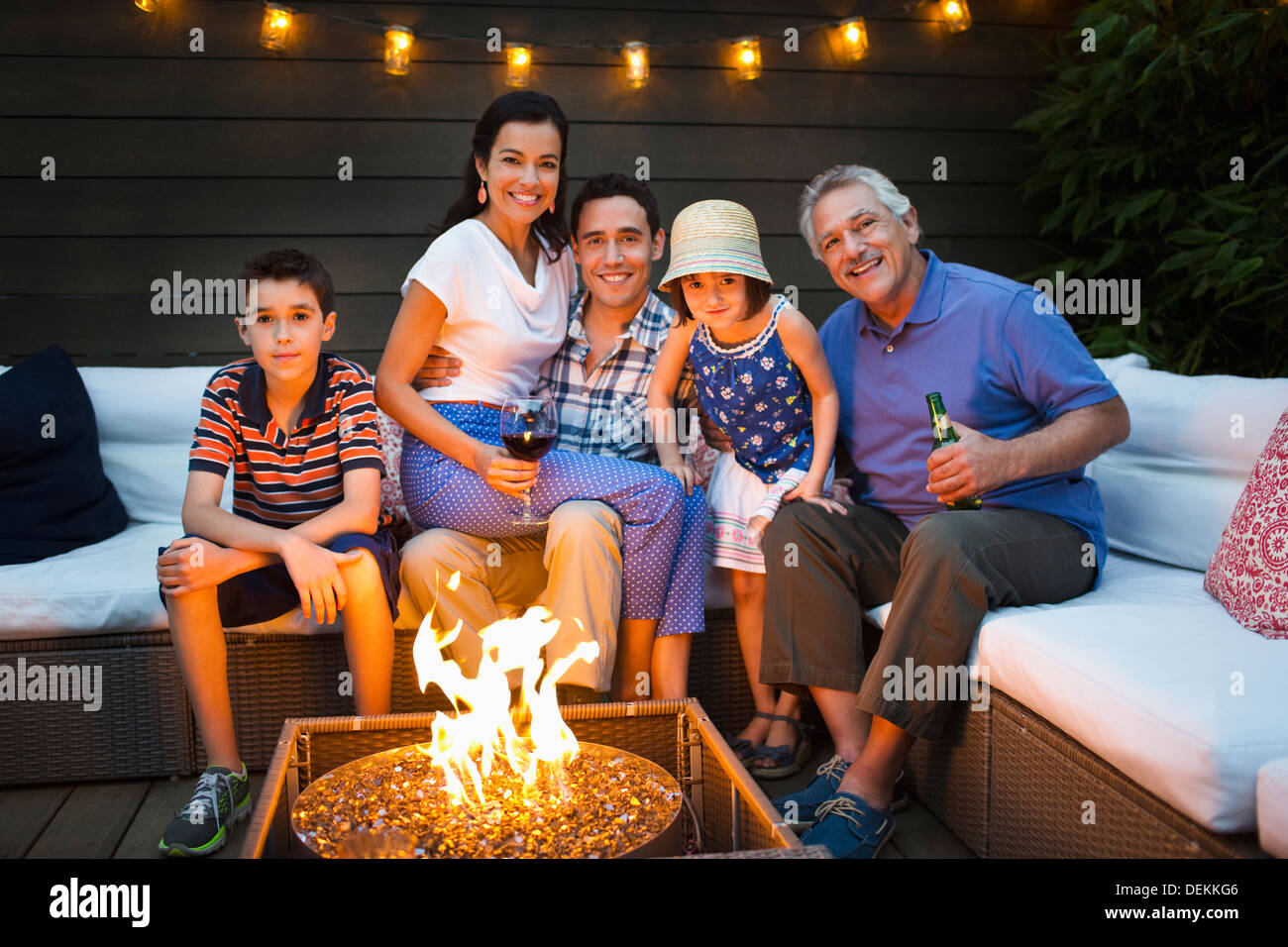 Family smiling autour d'un foyer en plein air Banque D'Images