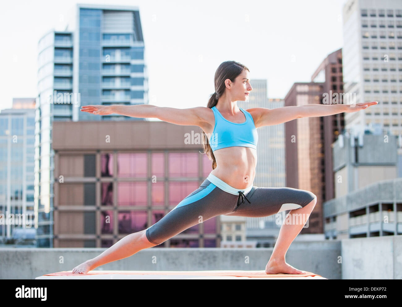 Caucasian woman practicing yoga on urban rooftop Banque D'Images