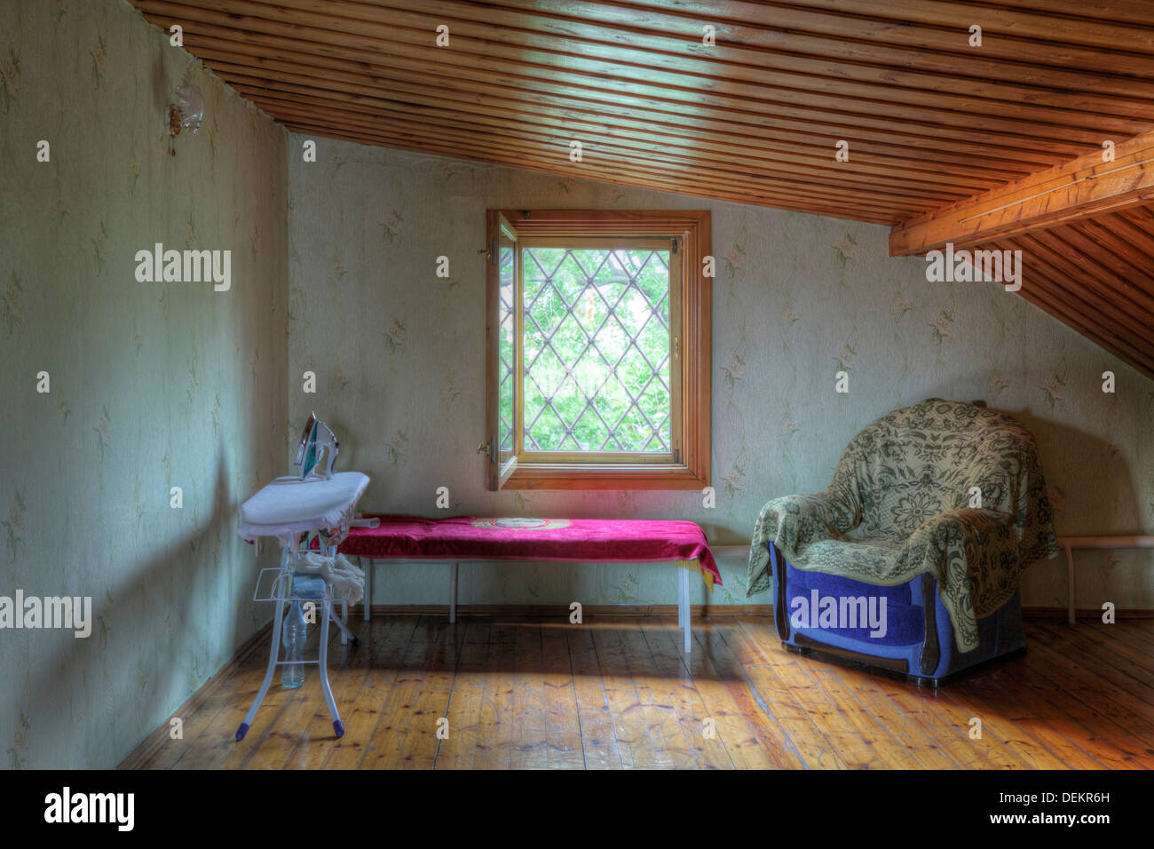 Planche à repasser, une table et un fauteuil dans le grenier Banque D'Images