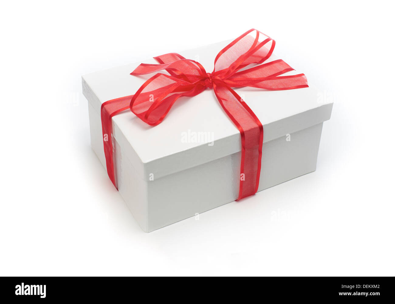 Enveloppé d'un cadeau de Noël avec un arc coloré ruban rouge sur fond blanc. Banque D'Images