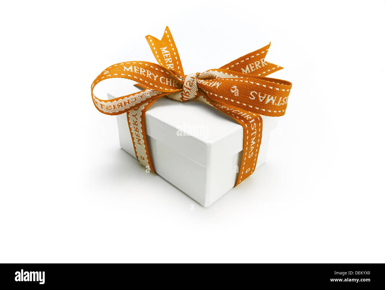 Enveloppé d'un cadeau de Noël avec un ruban d'or colorés et noeud sur un fond blanc. Banque D'Images