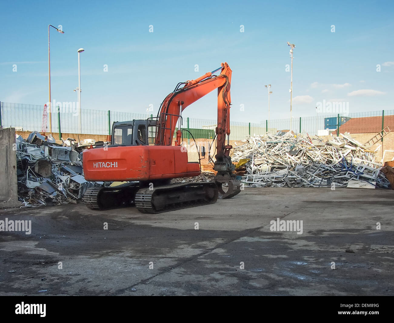 Avec une pelle tri grappin universel à un parc à ferraille Banque D'Images