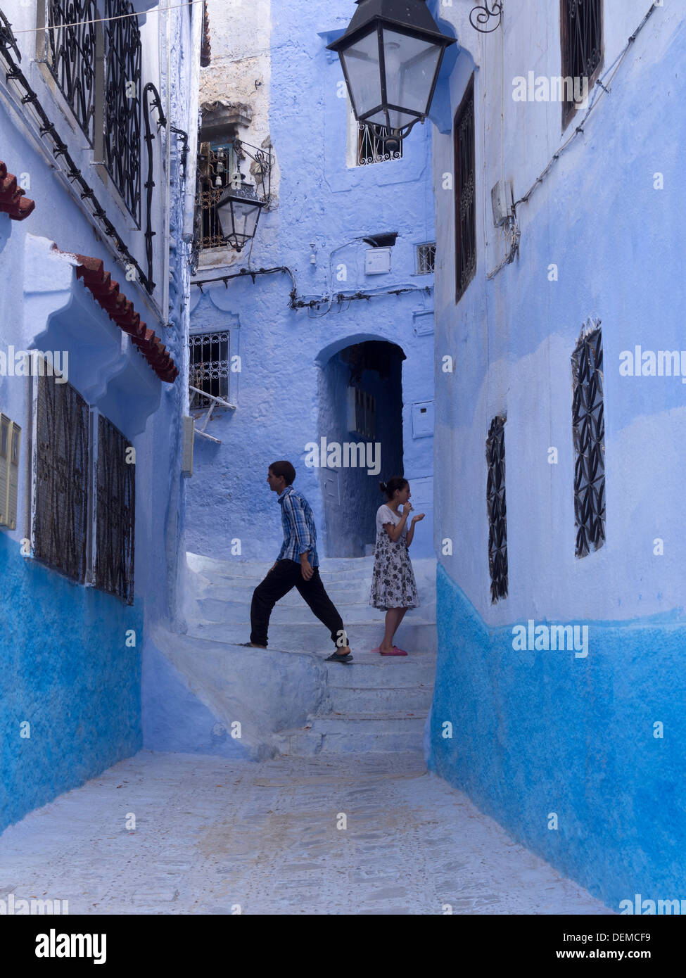 Deux jeunes enfants dans une ruelle avec ses maisons bleues à Chefchaouen, Maroc Banque D'Images