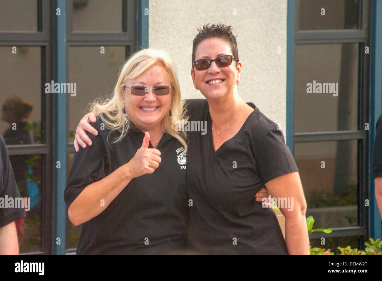 Deux femmes membres de la faculté de donner un pouce levé à des étudiants d'accueil le premier jour de l'école intermédiaire à Aliso Viejo, CA. Banque D'Images