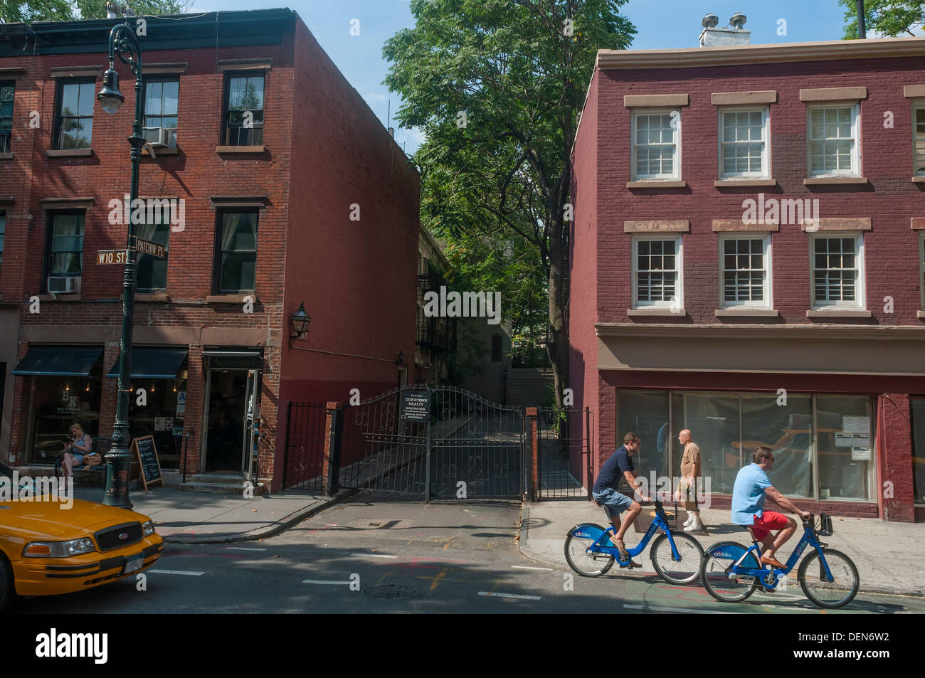 New York, NY - CitiBikers et un taxi jaune col par Parchin Place à Greenwich Village Banque D'Images