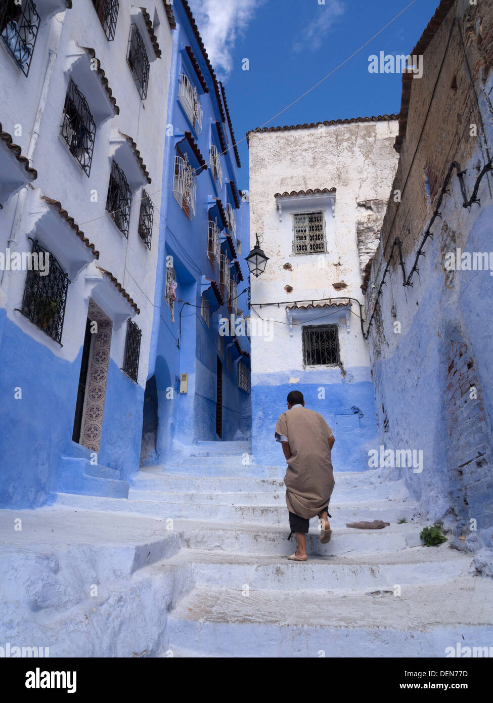 Personne marche dans une rue avec des maisons peintes en bleu clair à Chefchaouen, Maroc Banque D'Images