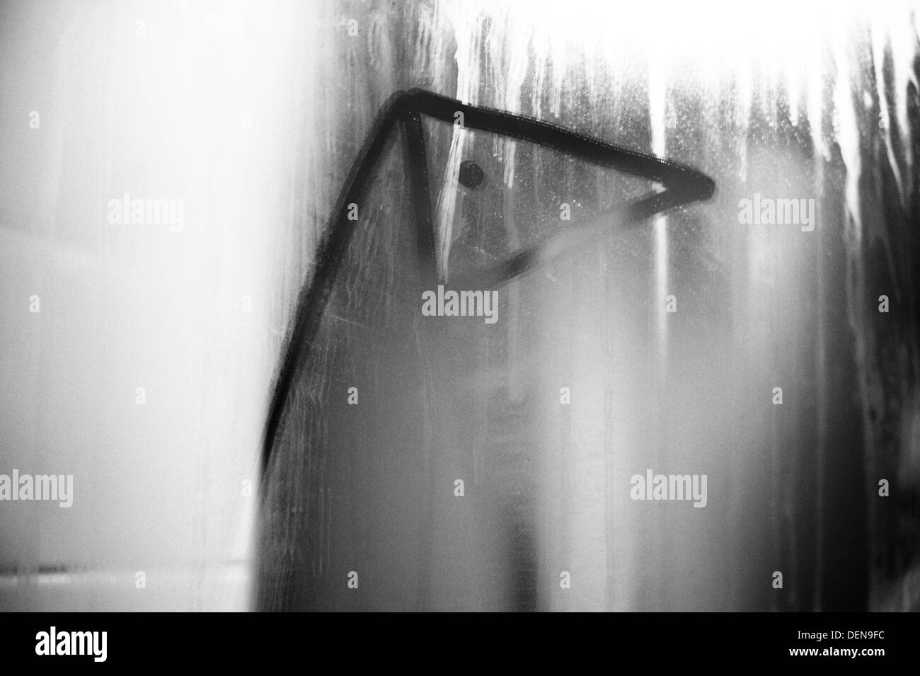 Un pingouin dessiné avec un doigt sur un miroir de salle de bains embuée. Banque D'Images