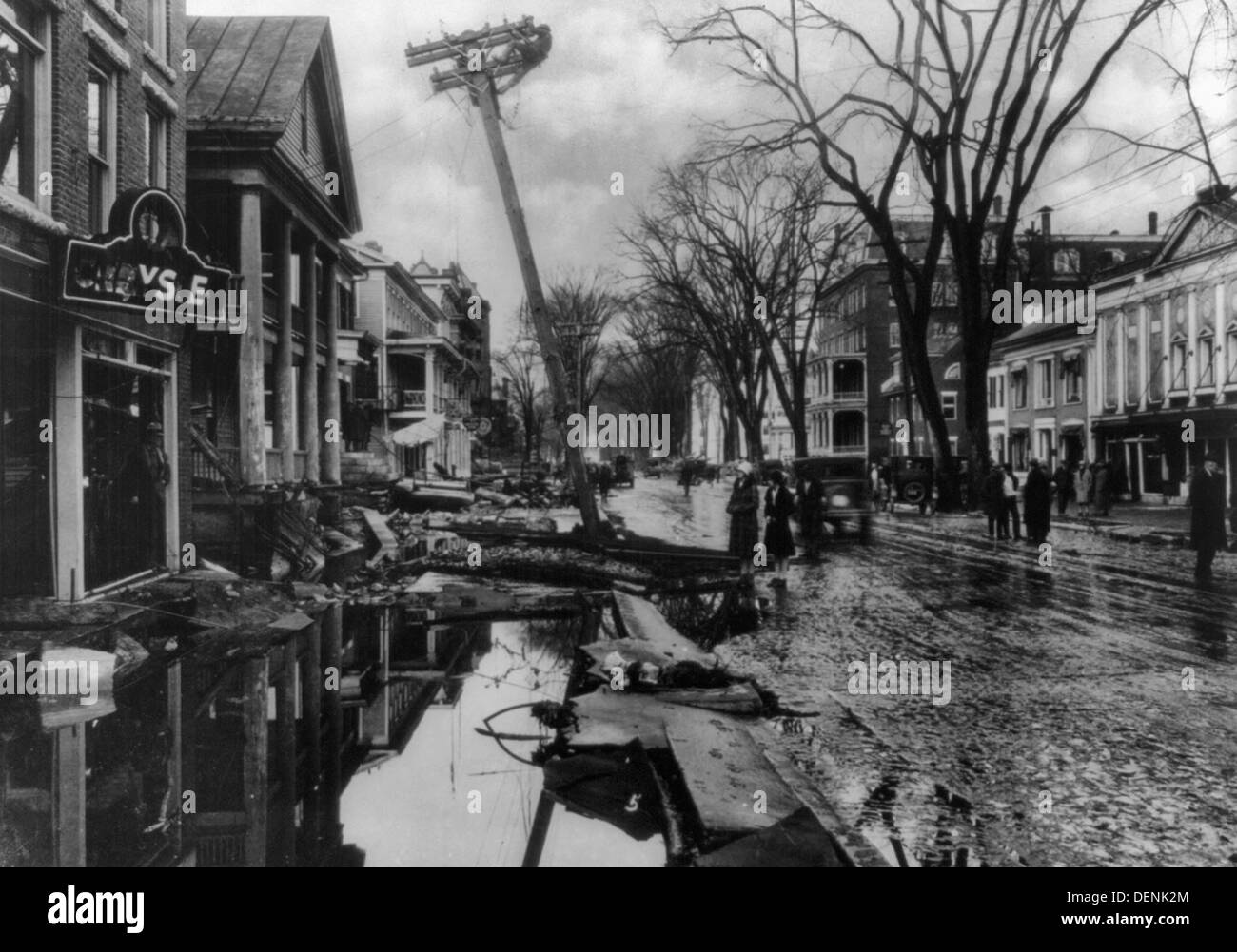 Inondations à Montpelier, Vermont, 1927 - des piles de débris sur rue ; personnes marchant par la zone où plusieurs bâtiments ont été endommagés par les inondations ; l'homme au sommet de poteau de Pise. Banque D'Images