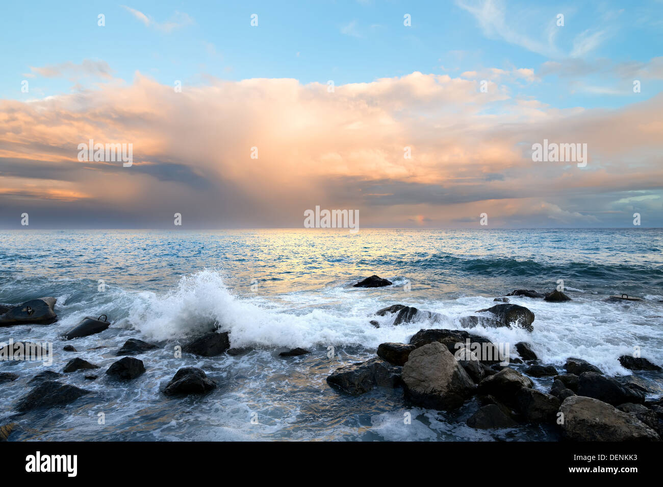 Côte rocheuse et les vagues de la mer au coucher du soleil Banque D'Images