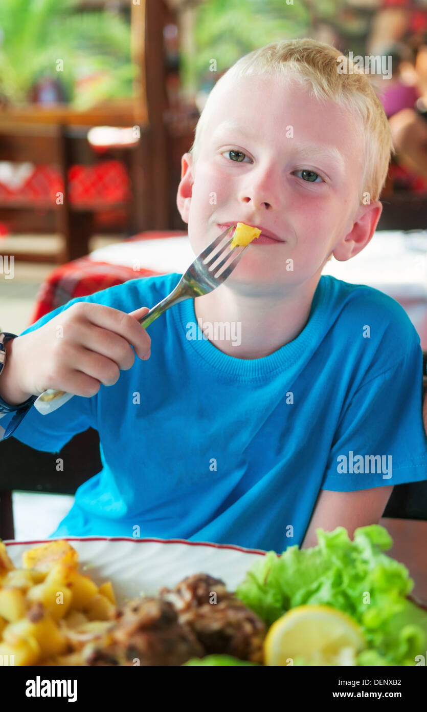 Jeune garçon de manger au restaurant Banque D'Images