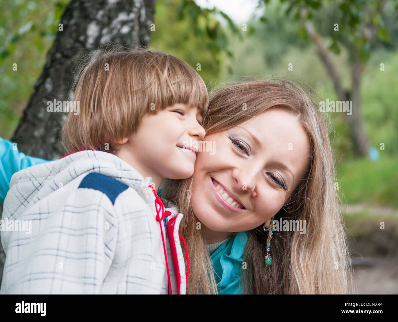 Mère et fils hugging outdoors, focus sur la maman Banque D'Images