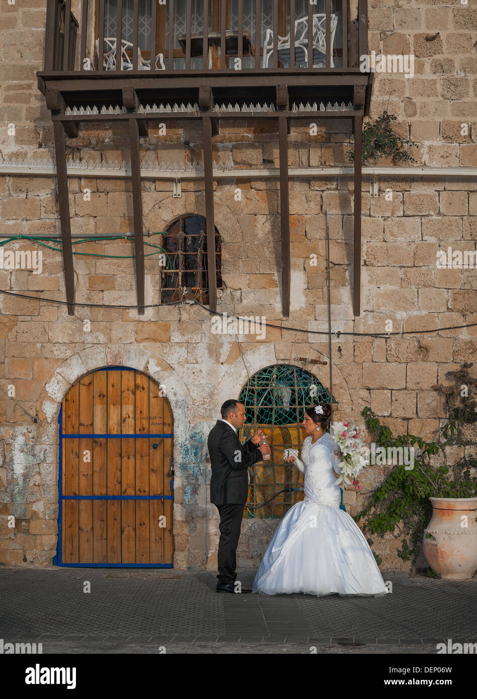 Un jeune couple le jour de leur mariage en tenant une une courte pause d'être photographiés à l'ancien port de Jaffa en Israël Banque D'Images