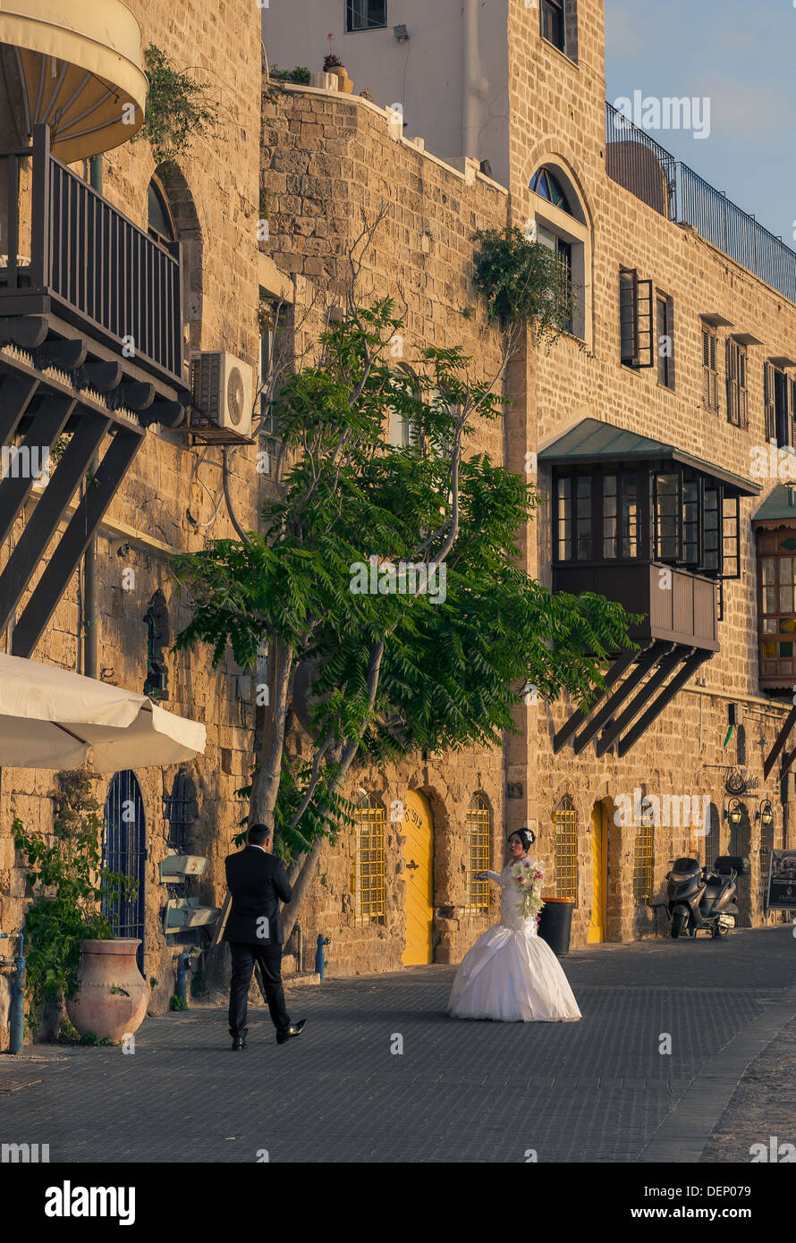 Un jeune couple le jour de leur mariage en tenant une une courte pause d'être photographiés à l'ancien port de Jaffa en Israël Banque D'Images