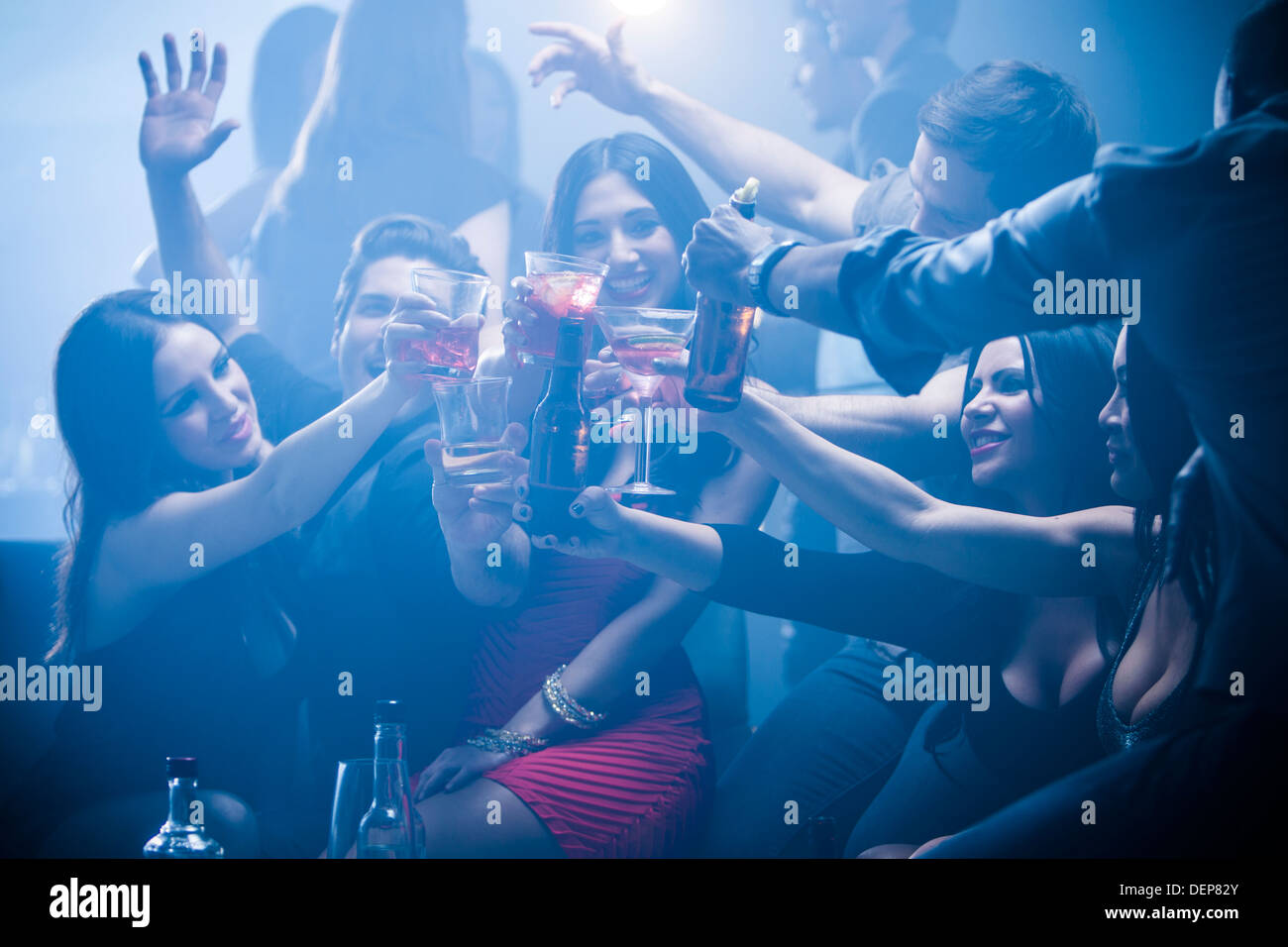 Friends toasting each other in nightclub Banque D'Images