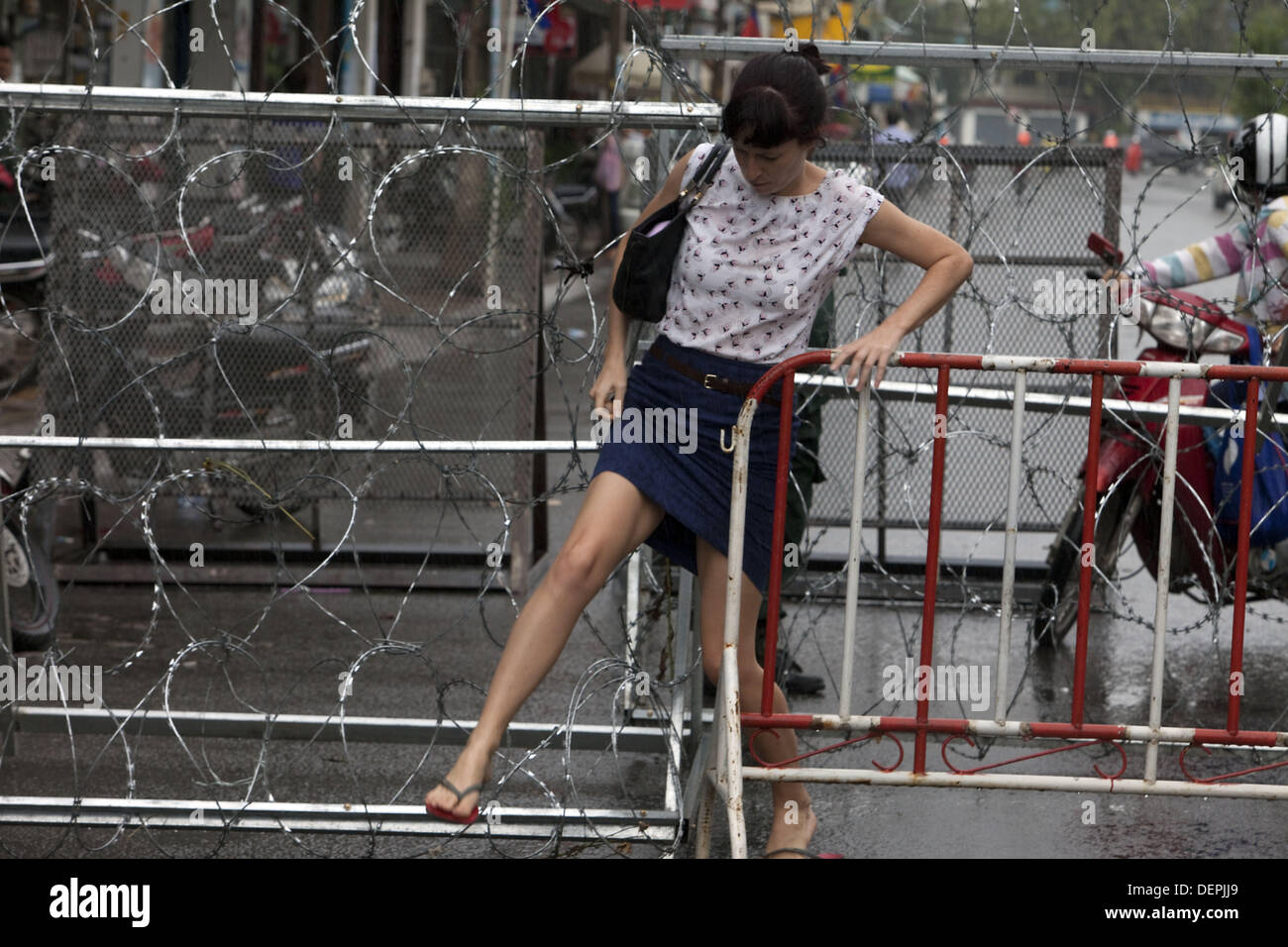 Phnom Penh, Phnom Penh, Cambodge. 23 août, 2013. Déplacement dans le blocus comme piétons et automobilistes supporter la saturation du trafic comme menant à Freedom Park et le bâtiment de l'Assemblée nationale ont été bloqués dans les rues avec une clôture de fil de fer et de chercher à prévenir, proteste. Plus tôt aujourd'hui a été post-électorale ouverture du parlement qui a été boycotté par l'opposition le Parti National du Cambodge. Leader de l'opposition Sam Rainsy a demandé la convocation du parlement sans l'opposition d'une violation de la constitution. Crédit : Gary Dwight Miller/ZUMAPRESS.com/Alamy Live News Banque D'Images