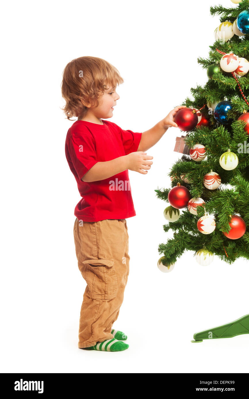 Happy 3 ans boy decorating Christmas Tree, picotement isolated on white Banque D'Images