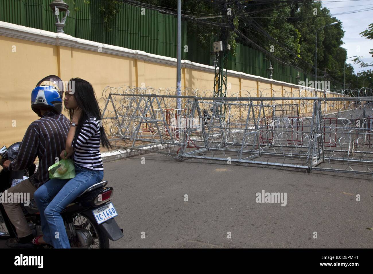 Phnom Penh, Phnom Penh, Cambodge. 23 août, 2013. Un motocycliste avec passager prend un virage en u à un blocus. Piétons et automobilistes supporter la saturation du trafic comme menant à Freedom Park et le bâtiment de l'Assemblée nationale ont été bloqués dans les rues avec une clôture de fil de fer et de chercher à prévenir, proteste. Plus tôt aujourd'hui a été post-électorale ouverture du parlement qui a été boycotté par l'opposition le Parti National du Cambodge. Leader de l'opposition Sam Rainsy a demandé la convocation du parlement sans l'opposition d'une violation de la constitution. (Crédit Image : © Gary Dwight Miller/ZUMA Banque D'Images