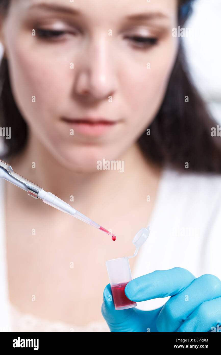 Fille avec un échantillon de produits chimiques dans un laboratoire médico-légal Banque D'Images
