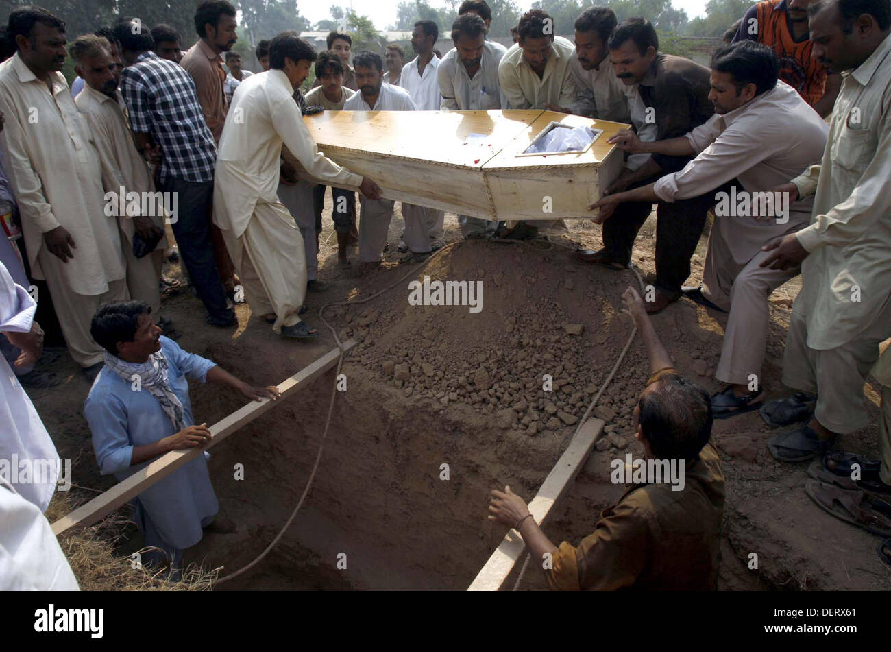 Les gens de la communauté chrétienne d'enterrer leurs proches qui a tué dans une double attaque suicidaire sur une église de Kohati gate, à Peshawar le lundi 23 septembre, 2013. Communauté chrétienne assiégée du Pakistan avait connu sa pire attaque jamais le dimanche après deux kamikazes ont attaqué un monument église du 19ème siècle dans la région de Peshawar, a tué 85 personnes et en blessant 140 autres. Banque D'Images