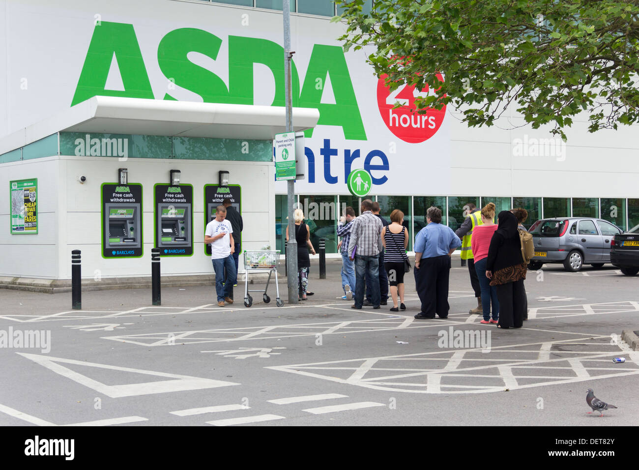 Longue file de personnes attendant d'utiliser le distributeur automatique de billets à ASDA, Eastlands Supercenter, Manchester. Banque D'Images