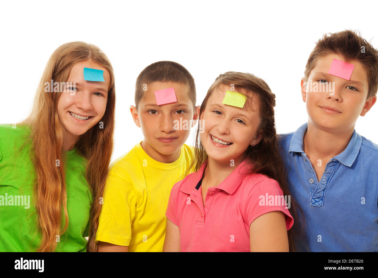 Groupe de quatre enfants smiling avec papier couleur autocollant sur leur front Banque D'Images
