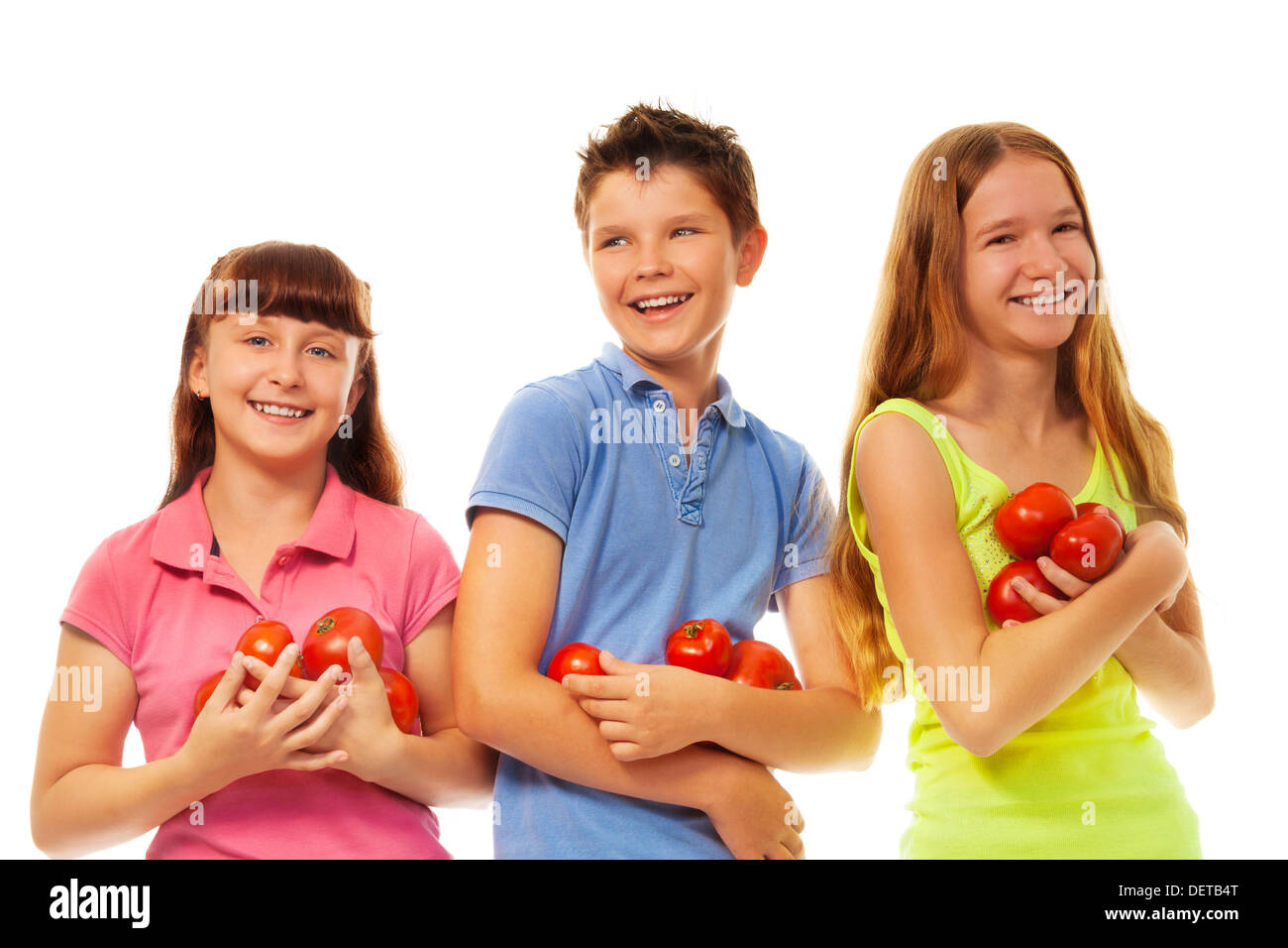 Groupe de jeunes filles et garçon holding fresh tomates mûres article isolated on white Banque D'Images