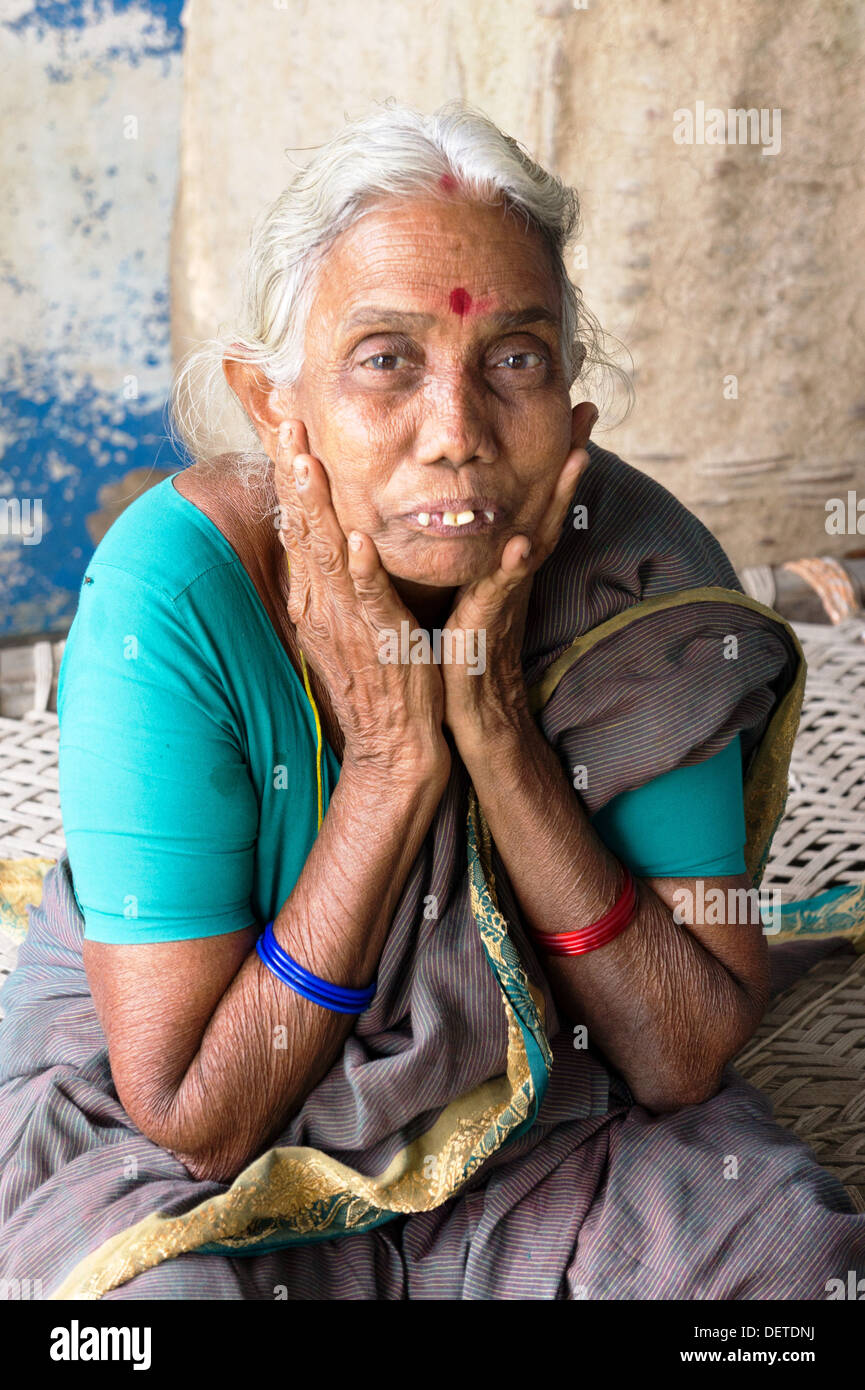 Old South Indian woman sitting on lit bébé Banque D'Images
